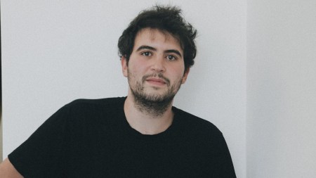 A man with a short beard in a black T-shirt.