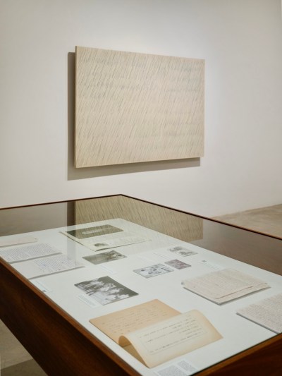 An abstract painting above a vitrine.