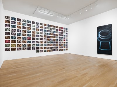 A grid of abstract paintings on a wall.