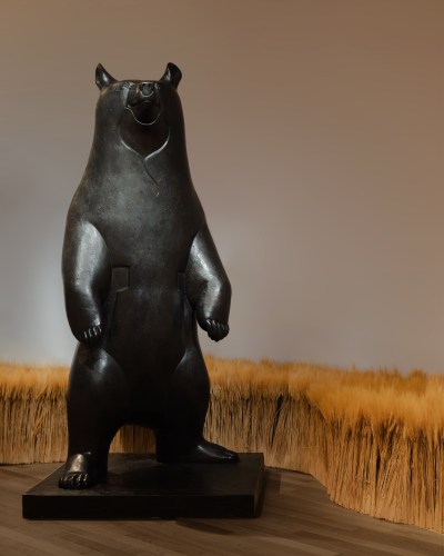 A life-size bronze sculpture of a bear standing on its hind legs. 
