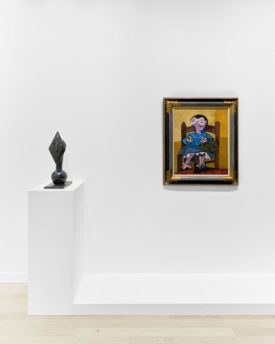 A sculpture and a painting by Picasso hang near each other in an art fair booth. 