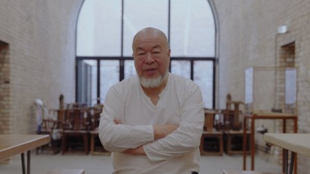 Ai Weiwei sits on a stool in his studio.