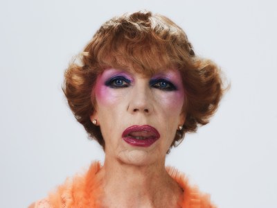 A very made-up older woman with curled short orange hair.