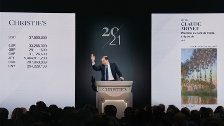 A man stands at a rostrum taking a bid.