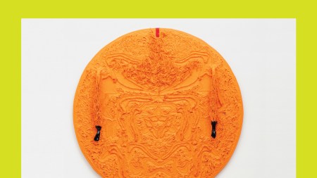 A circular painting in orange with abstract designs.