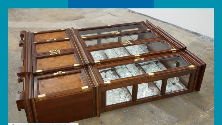 An ornate wooden china cabinet lays on the ground.