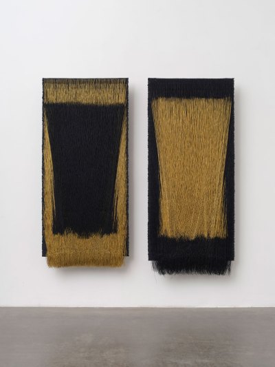 Two hanging fiber works in alternating gold and black. 