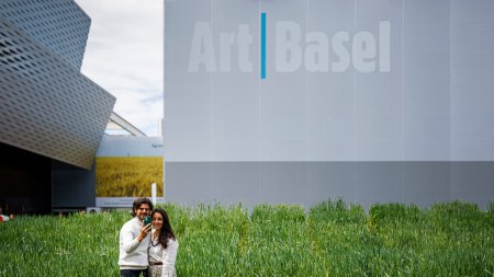 Visitors take a selfie in front of the installation "Honouring, Wheatfield - A Confrontation", 2024, by American artist Agnes Denes at the Messeplatz Project at Art Basel fair for Modern and contemporary art, in Basel, northern Switzerland, on June 11, 2024. (Photo by Valentin FLAURAUD / AFP) / RESTRICTED TO EDITORIAL USE - MANDATORY MENTION OF THE ARTIST UPON PUBLICATION - TO ILLUSTRATE THE EVENT AS SPECIFIED IN THE CAPTION