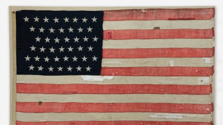 A tattered American flag with white bandages on it.