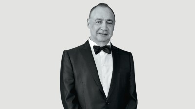Black-and-white portrait of a middle-aged man in a tuxedo.