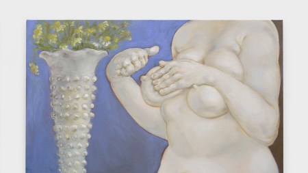 A white skinned plump figure awkwardly holds one breast. On a table behind her, a vase holds flowers.