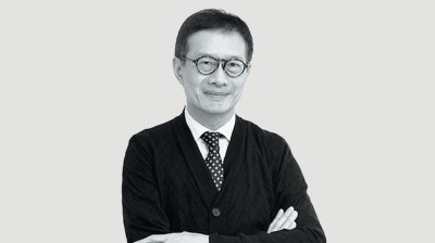 Black-and-white portrait of a middle-aged Asian man with glasses and wearing a suit