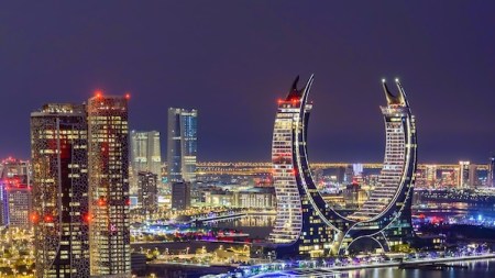 The general view of the ultra-luxury hotels Raffles and Fairmont in Doha, Qatar, on December 21, 2024. The dual-branded property is located within the iconic Katara Towers, a unique crescent-shaped building gracing the skyline of Lusail (Photo by Noushad Thekkayil/NurPhoto via Getty Images).