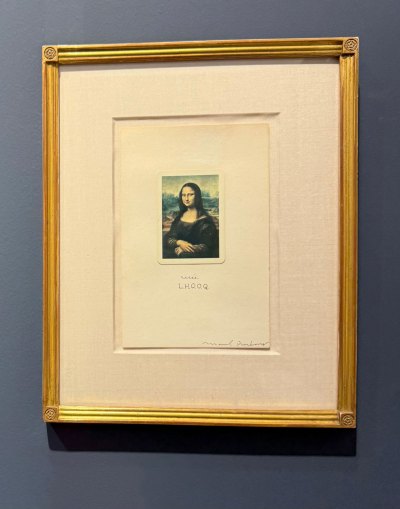 An invite with a reproduction of the Mona Lisa with the letters L.H.O.O.Q. below.