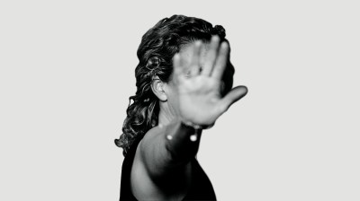 Black-and-white portrait of a woman whose face is blocked by her hand