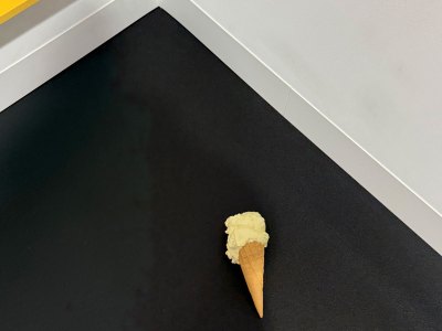 A bronze sculpture of an ice cone cone with a large scoop of vanilla.