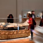 People look at an ancient Egyptian sarcophagus part of the 'Serve the Gods of Egypt' exhibition showing at the Museum of Grenoble, southern eastern France On October 23, 2018. - Based on the Grenoble collections and supplemented by 200 works from the Louvre Museum and others loaned by European museums, the exhibition offers an approach to Theban society during the Third Intermediate Period (1069-664 BC), around the temple of Karnak, the main place of worship of the god Amon. (Photo by JEAN-PIERRE CLATOT / AFP)        (Photo credit should read JEAN-PIERRE CLATOT/AFP via Getty Images)