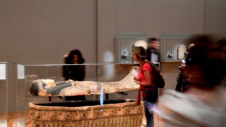 People look at an ancient Egyptian sarcophagus part of the 'Serve the Gods of Egypt' exhibition showing at the Museum of Grenoble, southern eastern France On October 23, 2018. - Based on the Grenoble collections and supplemented by 200 works from the Louvre Museum and others loaned by European museums, the exhibition offers an approach to Theban society during the Third Intermediate Period (1069-664 BC), around the temple of Karnak, the main place of worship of the god Amon. (Photo by JEAN-PIERRE CLATOT / AFP)        (Photo credit should read JEAN-PIERRE CLATOT/AFP via Getty Images)