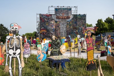 Taring Padi’s banner People's Justice (2002) hangs behind cardboard figures at Documenta 15, Kassel, Germany, June 18, 2022