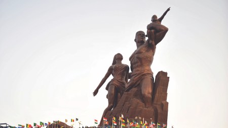 A large monuments of a man, woman, and child pointing up to the sky