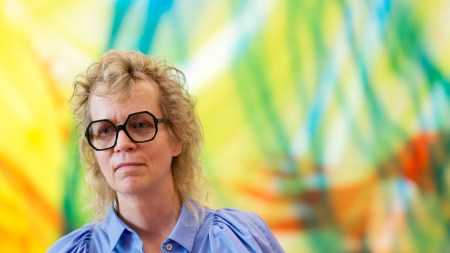 A woman in front of an abstract painting.