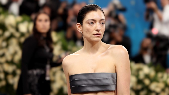 A woman wearing grey fabric over her breasts.