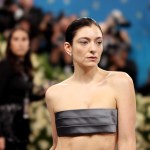 A woman wearing grey fabric over her breasts.