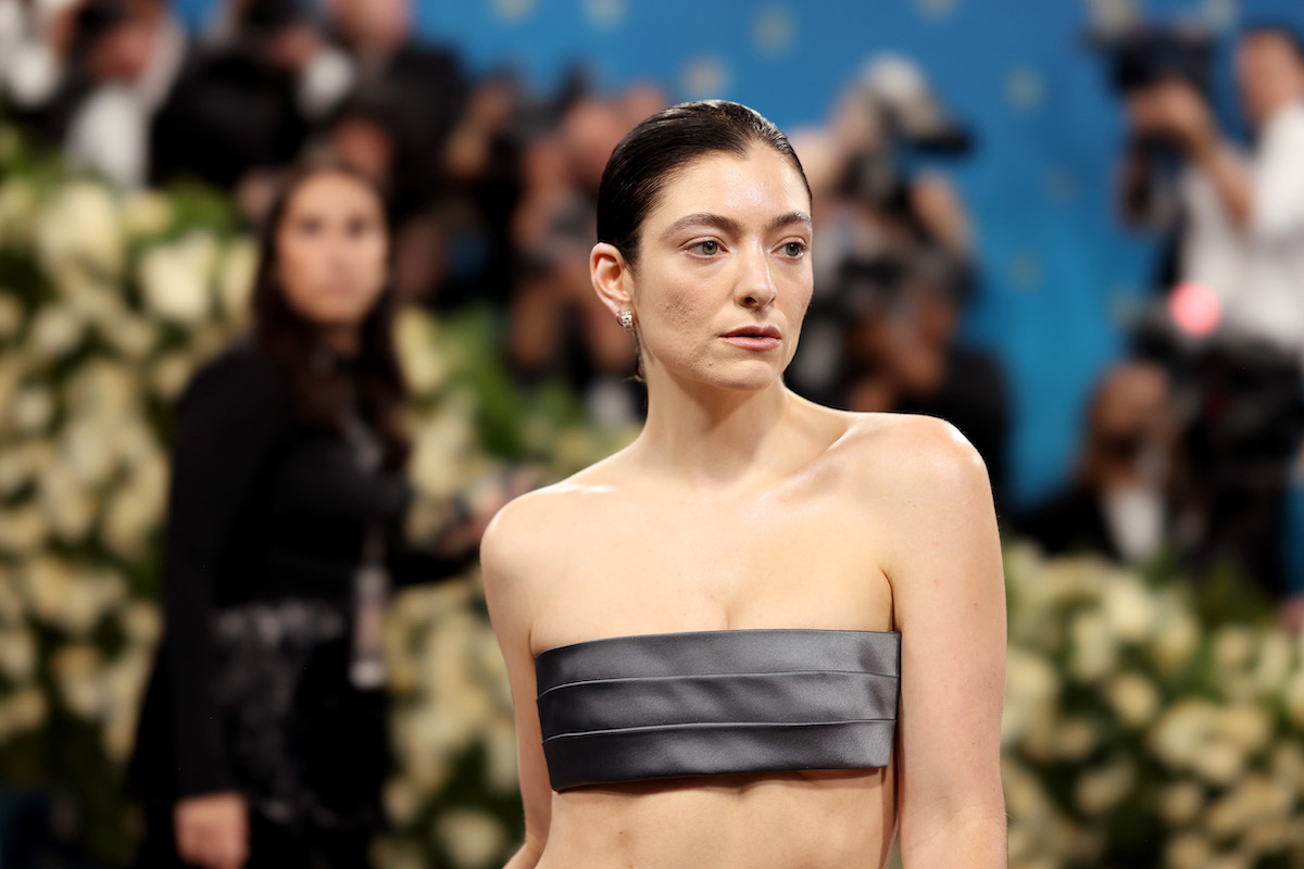 A woman wearing grey fabric over her breasts.