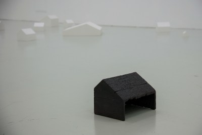 A small iron house sculpture on the floor.