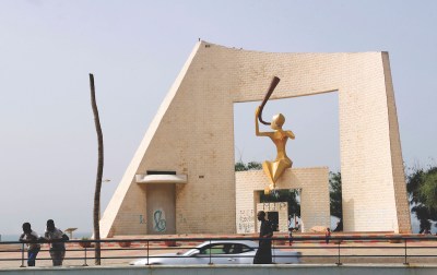 An abstract monument with a golden figure playing a horn