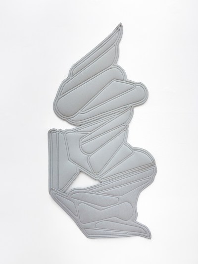 A wall work with wing-like patterns sewn into fabric.