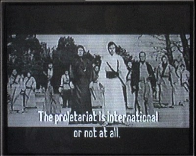 A LoFi grayscale video still has a dozen people in long robes and a caption that says: the proletariat is international or not at all.