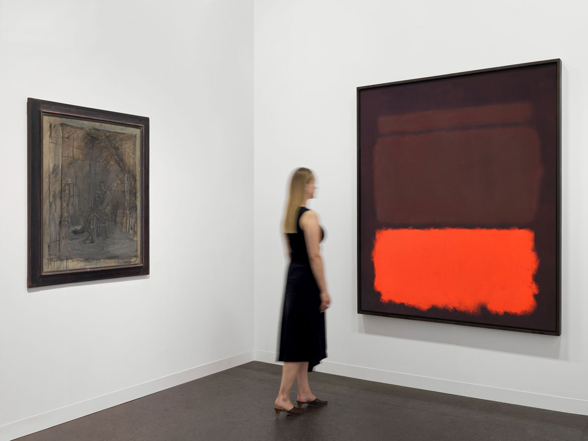 A woman looks at an abstract color field painting by Rothko at right. At left is a muddied painted portrait of a man by Giacometti.