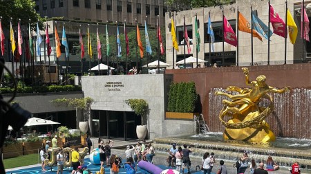 Grownups and children play in Joel Mesler's pool party-themed installation at 30 Rockefeller Park Plaza.