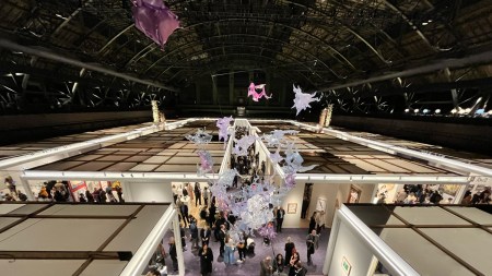 View of a vaulted drill hall with an art fair below.