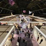 View of a vaulted drill hall with an art fair below.