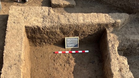 Excavation trench showing mudbrick layers and a foundation wall at Tell al-Faraun.