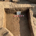 Excavation trench showing mudbrick layers and a foundation wall at Tell al-Faraun.