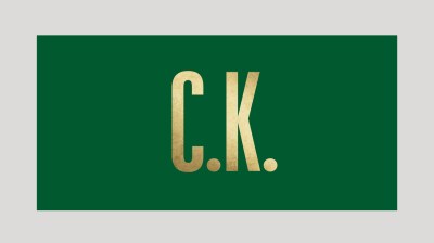 Text image of a gold 'C.K.' on a hunter green background.