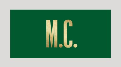 Text image of a gold 'M.C.' on a hunter green background.