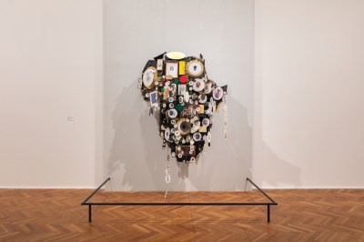 A wall assemblage in the shape of the African continent has a bundant plates and pictures dangling off its surface.