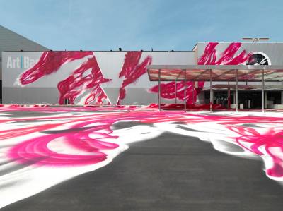 A convention center partially covered in pink swirls of paint.