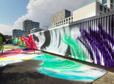 A building whose exterior and surrounding area are covered in swirls of paint.