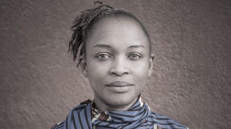 A gray-scale image featuring a woman in a striped shirt.