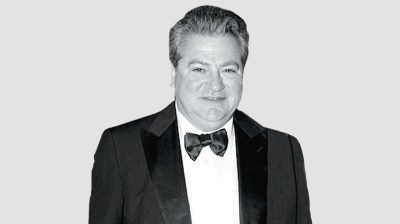 Black-and-white portrait of a white man in a tuxedo