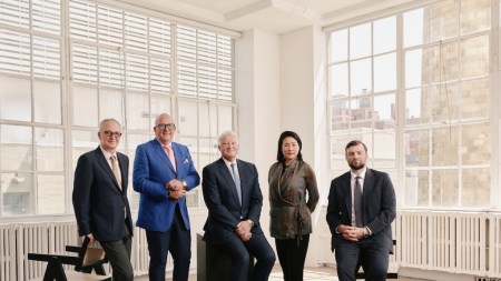 Four men and a woman in a sun filled loft.