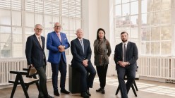 Four men and a woman in a sun filled loft.