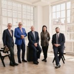 Four men and a woman in a sun filled loft.