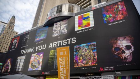 NEW YORK, NEW YORK - JUNE 21: People gather around to watch billboards light up with NFTs as part of the NFT.NYC Conference in Times Square on June 21, 2022 in New York City. Various artists displayed their artwork/ NFTs as part of NFTs minted with NFTKred. (Photo by Alexi Rosenfeld/Getty Images)