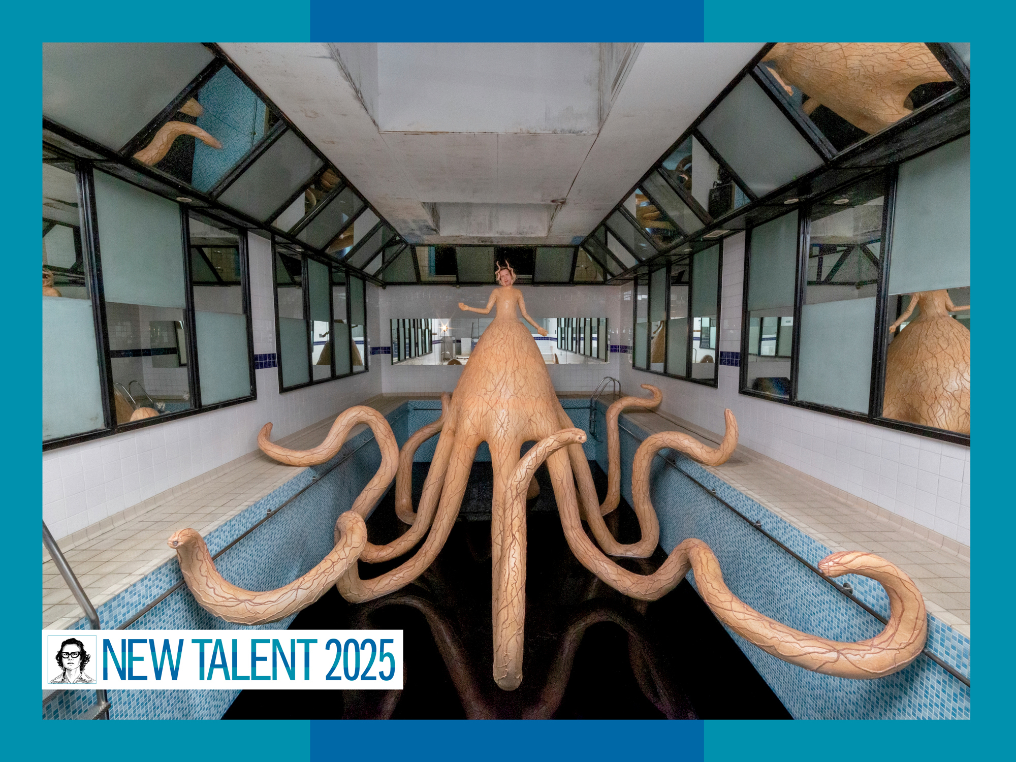 In an empty indoor swimming pool, a woman is enclosed in a giant octopus sculpture reflected by mirrors mounted on the walls.